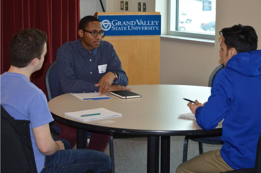 An alumnus talking to two students at the 30 Minute Mentors Event